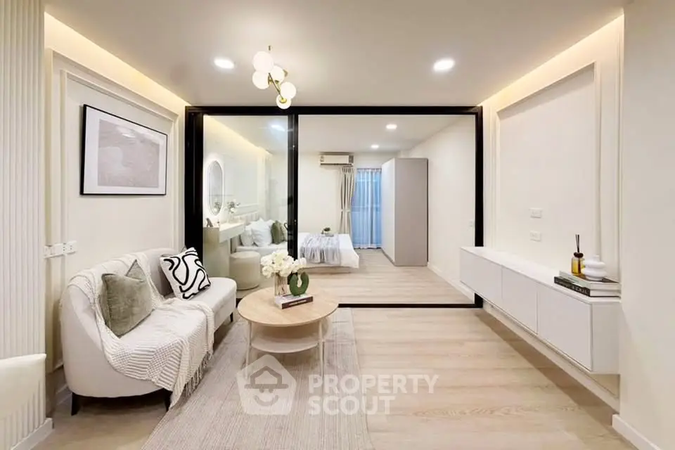 Modern living room with elegant decor and view into cozy bedroom