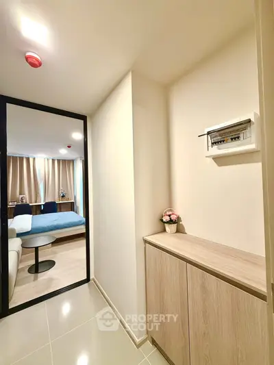 Modern apartment hallway leading to cozy bedroom with stylish decor