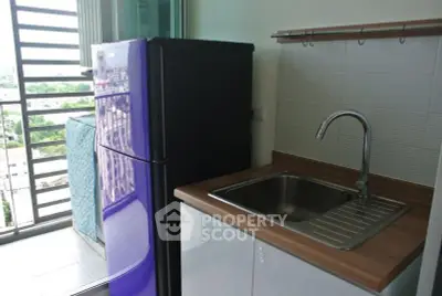 Compact kitchen with purple fridge and balcony view
