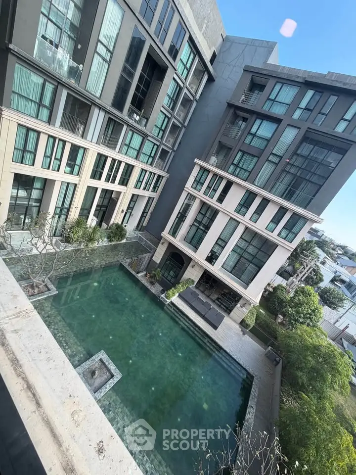 Modern apartment building with a luxurious pool and lush greenery, perfect for urban living.