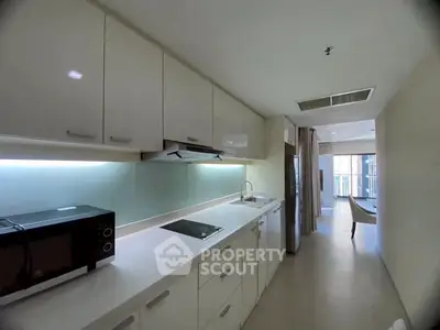 Modern kitchen with sleek cabinetry and integrated appliances in a bright apartment.