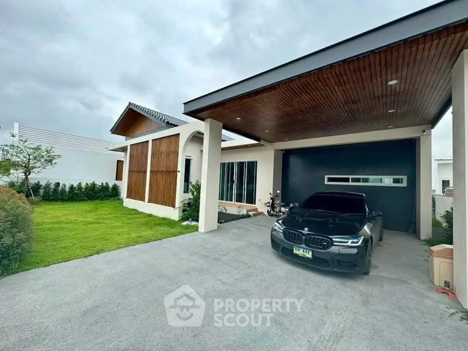 Modern single-story house with carport and lush green lawn, showcasing contemporary architecture and sleek design.