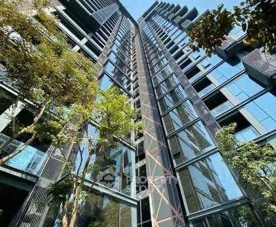 Stunning modern high-rise building with glass facade and lush greenery