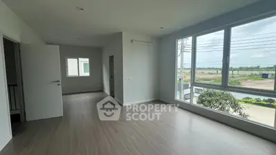 Spacious empty room with large windows and modern flooring, perfect for customization.