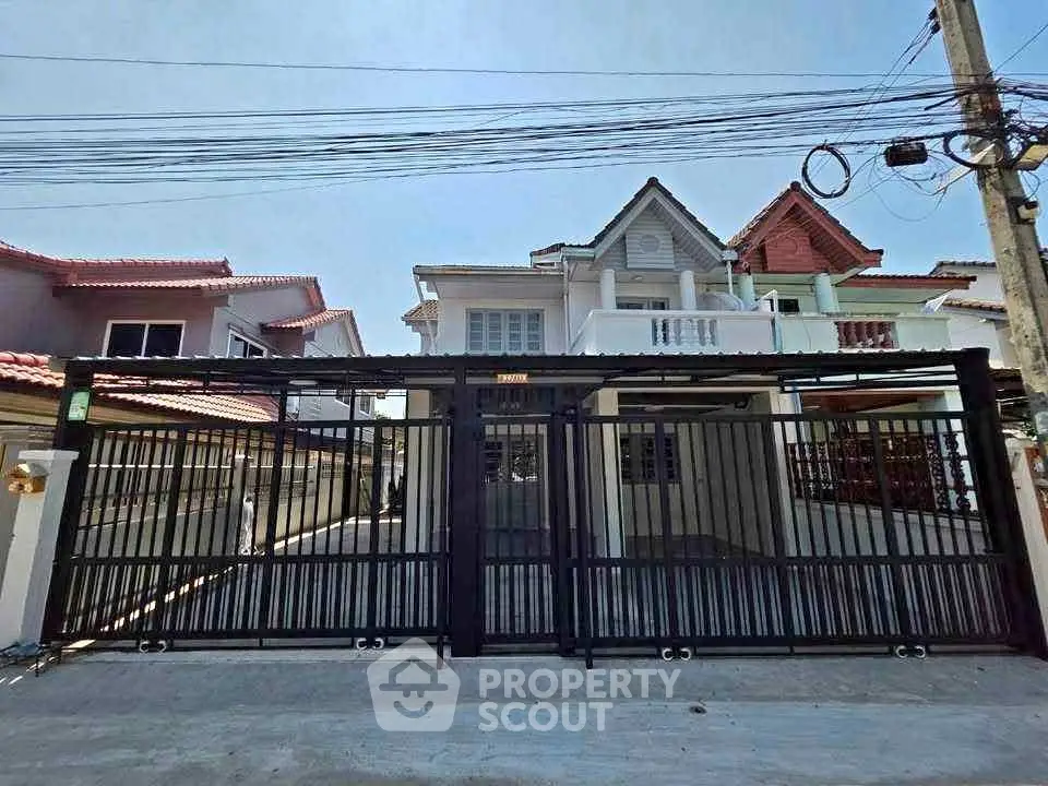 Charming suburban house with gated driveway and modern architecture.