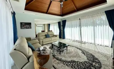 Luxurious living room with vaulted wooden ceiling and elegant decor