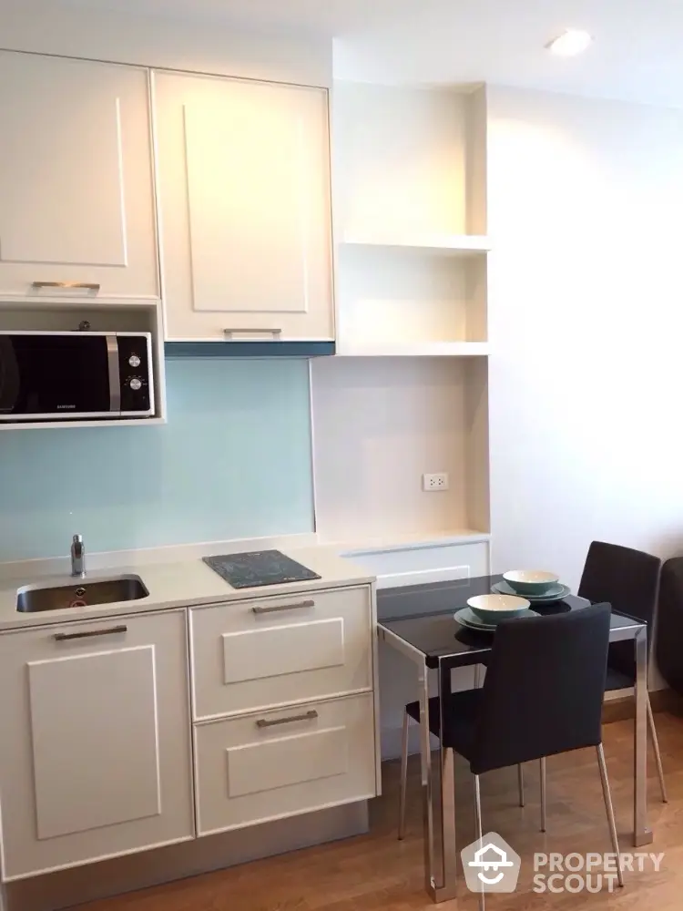 Modern compact kitchen with sleek cabinetry and dining area