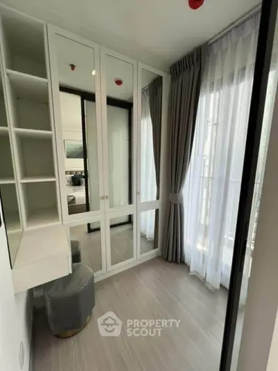 Modern bedroom with mirrored wardrobe and elegant curtains in a bright, stylish apartment.