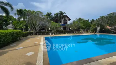 Luxurious villa with a stunning pool surrounded by lush greenery and palm trees, perfect for relaxation.