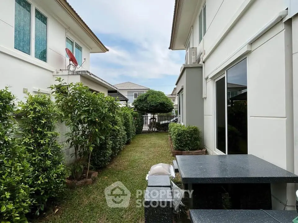 Charming backyard garden with lush greenery and modern outdoor seating area.