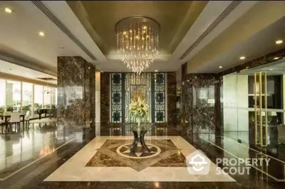 Luxurious building entrance with elegant chandelier and marble flooring