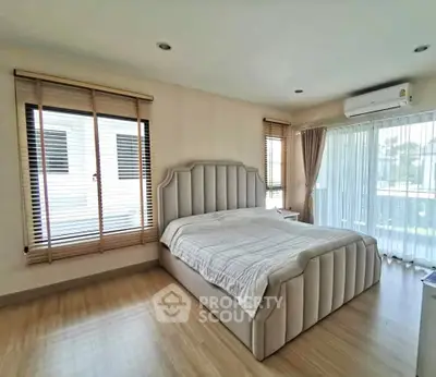 Spacious bedroom with elegant bed and large windows for natural light