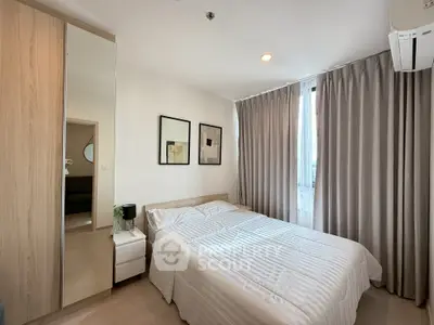Modern bedroom with cozy decor and natural light, featuring a comfortable bed and stylish furnishings.