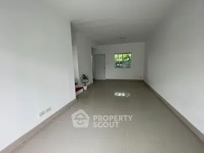 Spacious empty room with tiled flooring and white walls, ideal for customization.