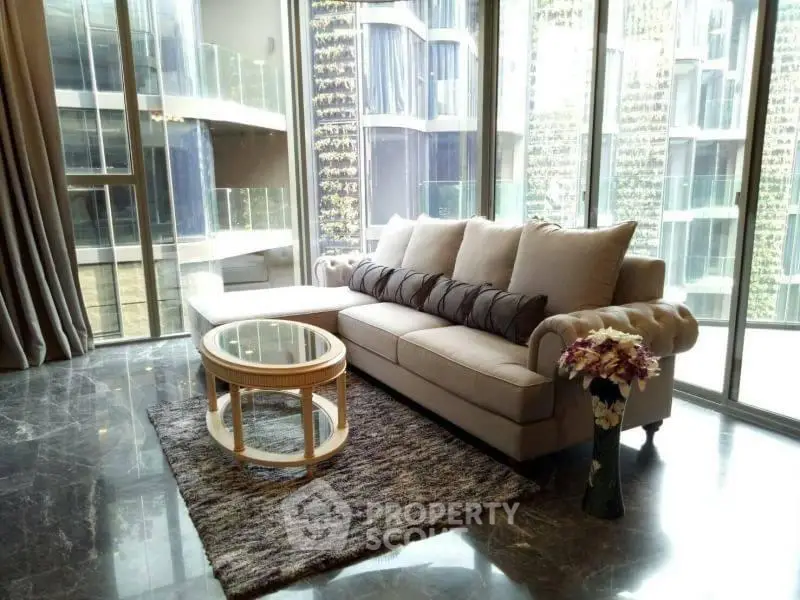 Luxurious living room with elegant sofa and floor-to-ceiling windows offering stunning city views.