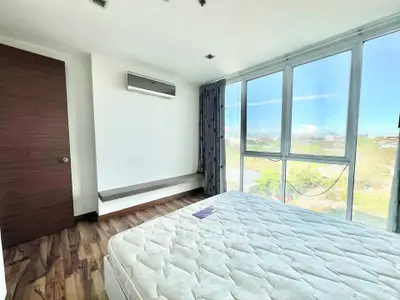 Bright bedroom with large windows and scenic view, featuring modern flooring and air conditioning.