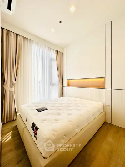 Bright and spacious bedroom with large window and elegant curtains, featuring a comfortable bed and modern design.