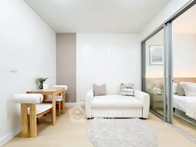 Modern living room with cozy sofa and dining area, featuring elegant decor and natural light.