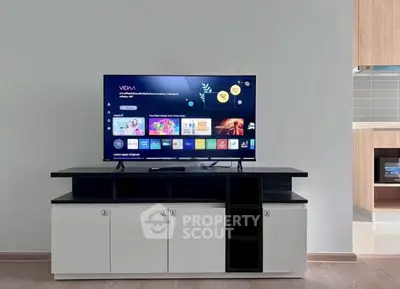 Modern living room with sleek TV stand and flat-screen TV, showcasing a stylish and minimalist interior design.