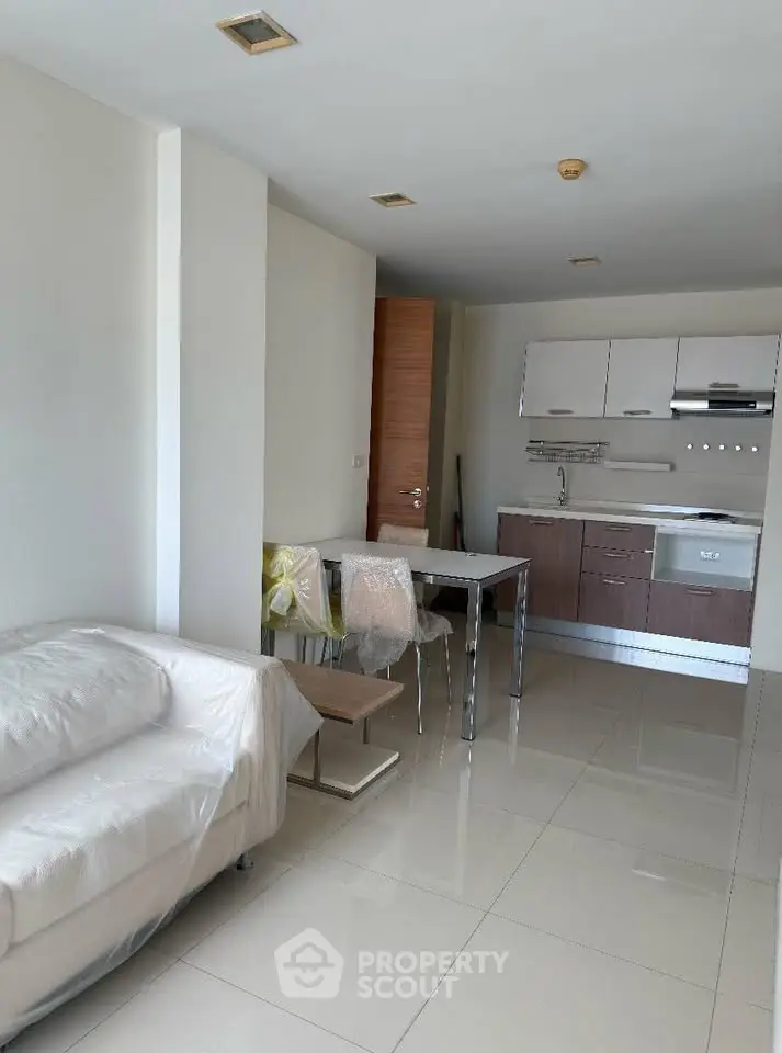 Modern open-plan living room with sleek kitchen and cozy seating area.