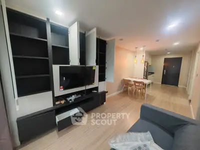 Modern living room with open layout, stylish shelving, and dining area in a contemporary apartment.