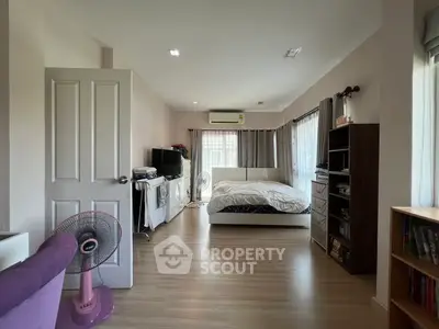 Spacious bedroom with modern decor and natural light, featuring a cozy bed and stylish furnishings.