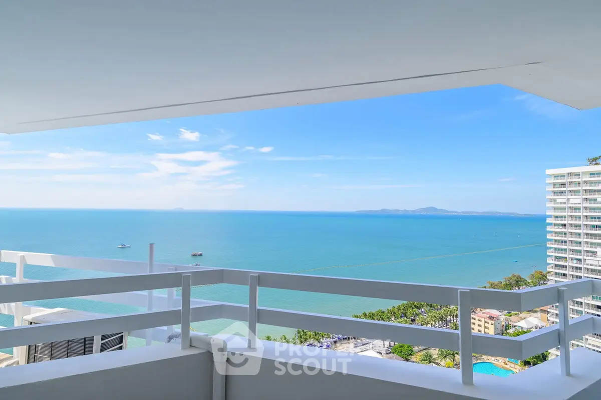 Stunning ocean view from a high-rise balcony with clear blue skies.