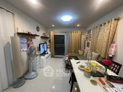 Cozy living room with modern decor and dining area, featuring a comfortable sofa and entertainment setup.