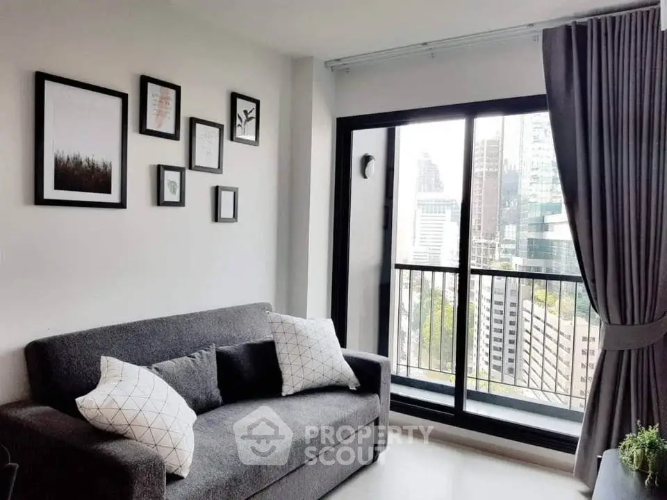 Modern living room with city view, stylish decor, and cozy gray sofa.