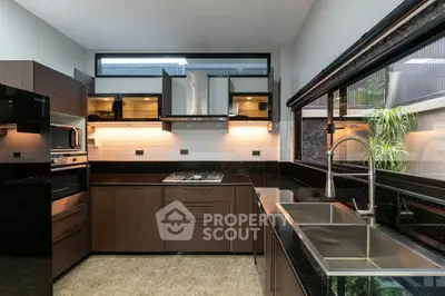 Modern kitchen with sleek cabinetry and large windows for natural light.