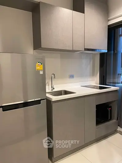 Modern kitchen with sleek cabinetry and stainless steel appliances in a stylish apartment.