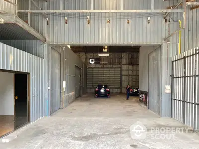 Spacious industrial warehouse with high ceilings and ample parking space.