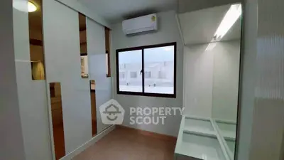 Modern bedroom with sleek built-in wardrobe and air conditioning unit, offering a minimalist design.