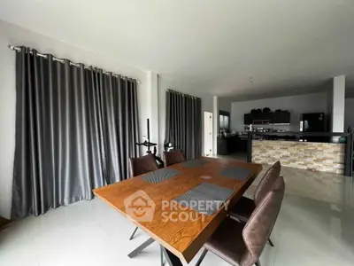 Spacious modern dining area with elegant wooden table and sleek kitchen in open layout design.
