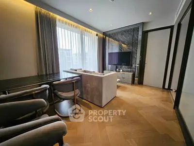 Modern living room with elegant decor, featuring a sleek TV setup and stylish furniture.