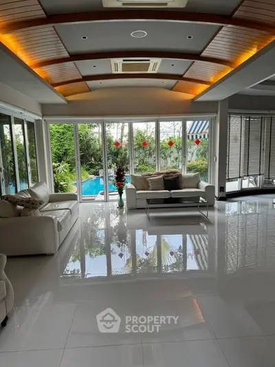 Luxurious living room with pool view and elegant ceiling design.