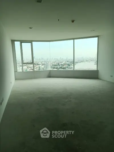 Spacious empty room with panoramic city view through large windows
