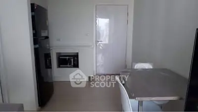 Modern kitchen with sleek appliances and dining area in a compact layout.