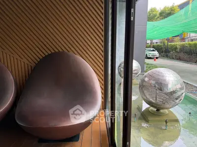 Modern interior with unique seating and outdoor reflective sculpture