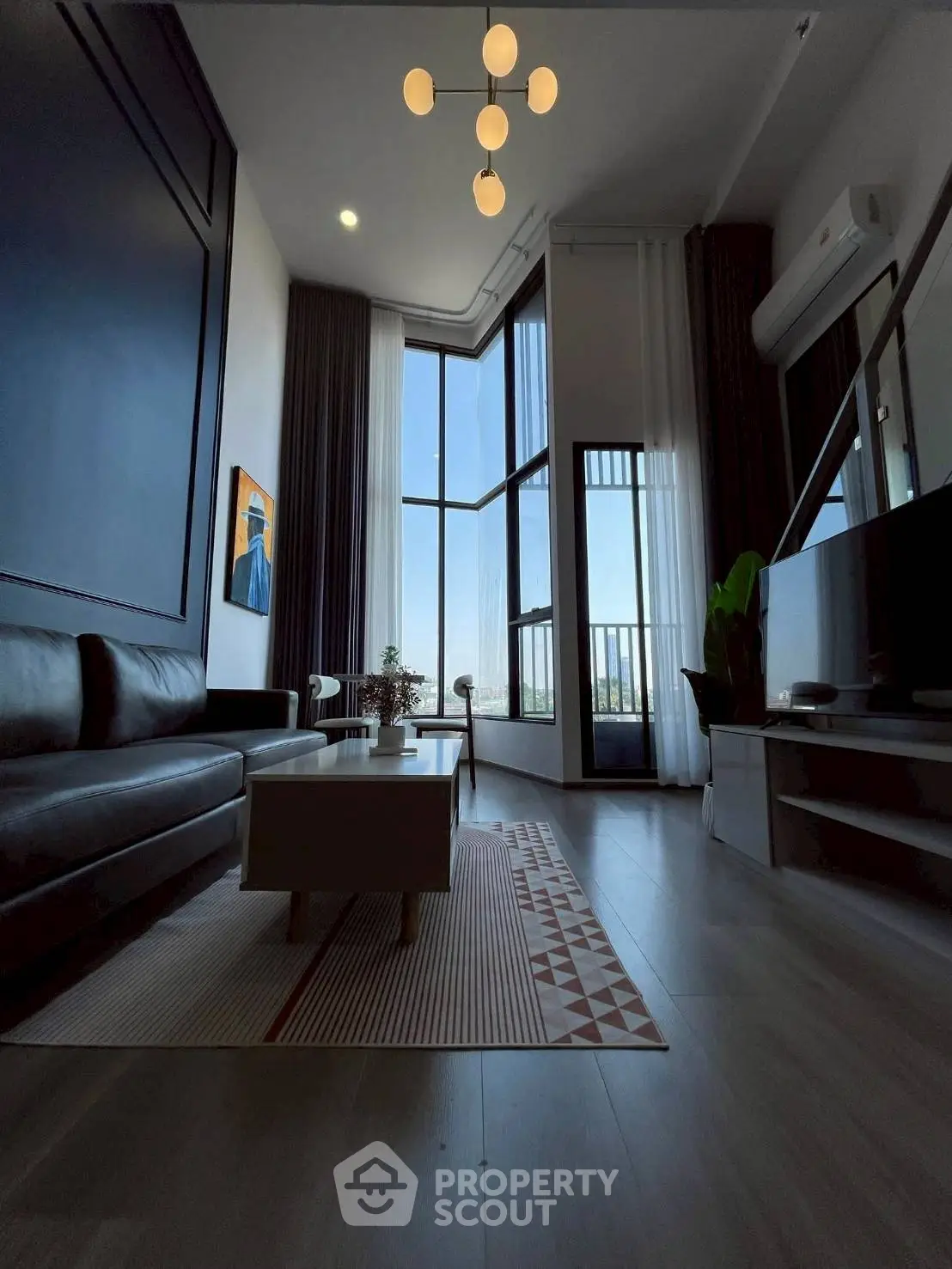 Modern living room with high ceilings, large windows, and stylish decor offering a stunning view.
