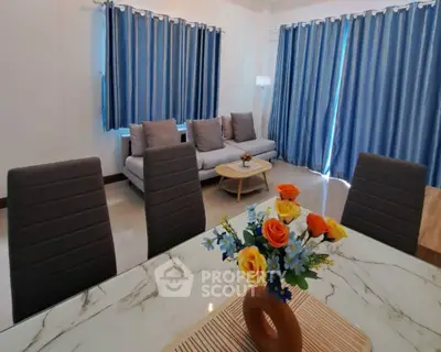 Elegant living room with modern furniture and vibrant floral centerpiece.