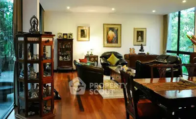 Luxurious living room with elegant decor and large windows overlooking lush greenery.