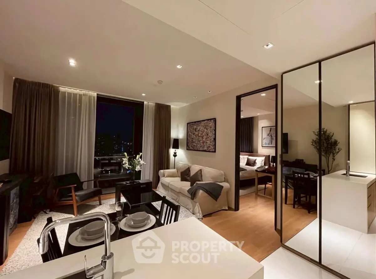 Modern open-plan living room with kitchen and dining area, featuring elegant decor and cozy ambiance.