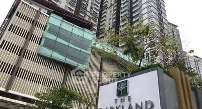 Modern high-rise building with sleek architectural design and lush greenery.