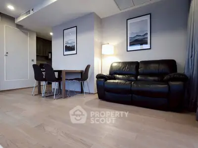 Modern living room with leather sofa and dining area in open layout.