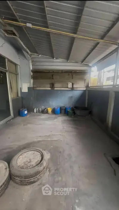 Spacious industrial garage with ample storage potential and secure metal roofing.