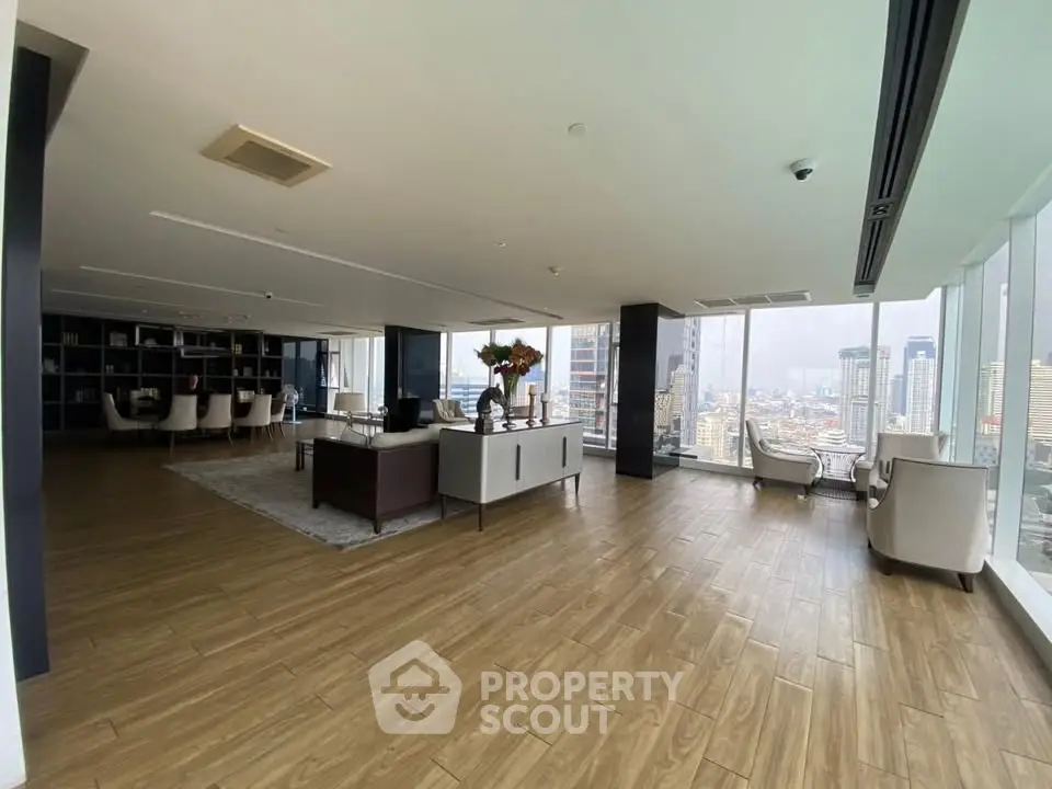 Spacious modern living room with panoramic city views and elegant furnishings.