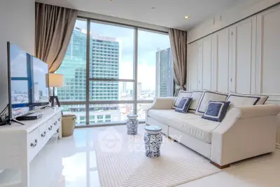 Luxurious living room with large windows offering stunning city views, elegant decor, and modern furnishings.