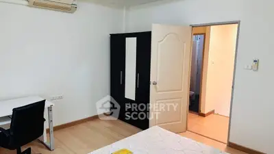 Spacious bedroom with modern furniture and ample natural light, perfect for comfortable living.
