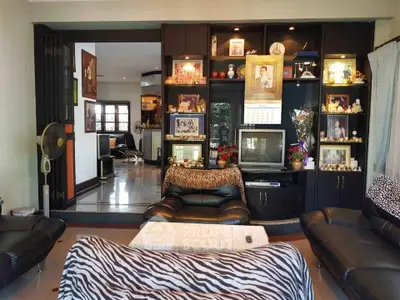 Charming living room with stylish black furniture and decorative shelving, perfect for cozy family gatherings.